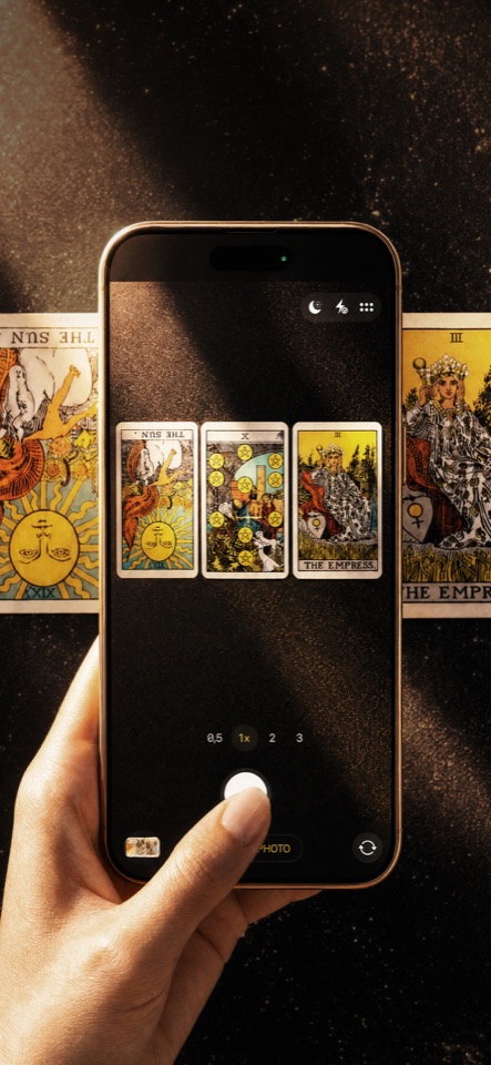 A phone photographing a Rider-Waite spread, including a reversed card